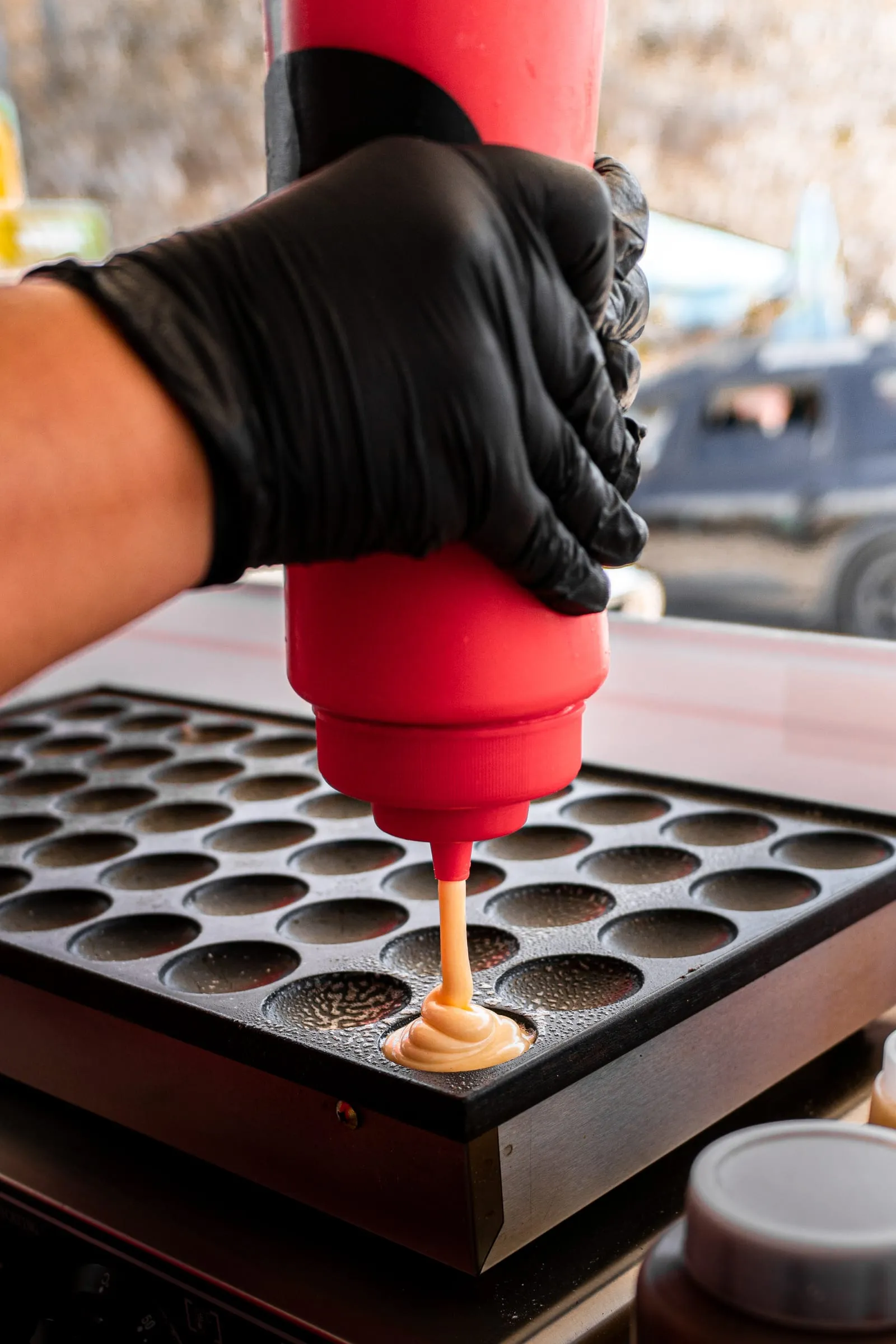 Massa a cair de um doseador para a chapa dos mini waffles.